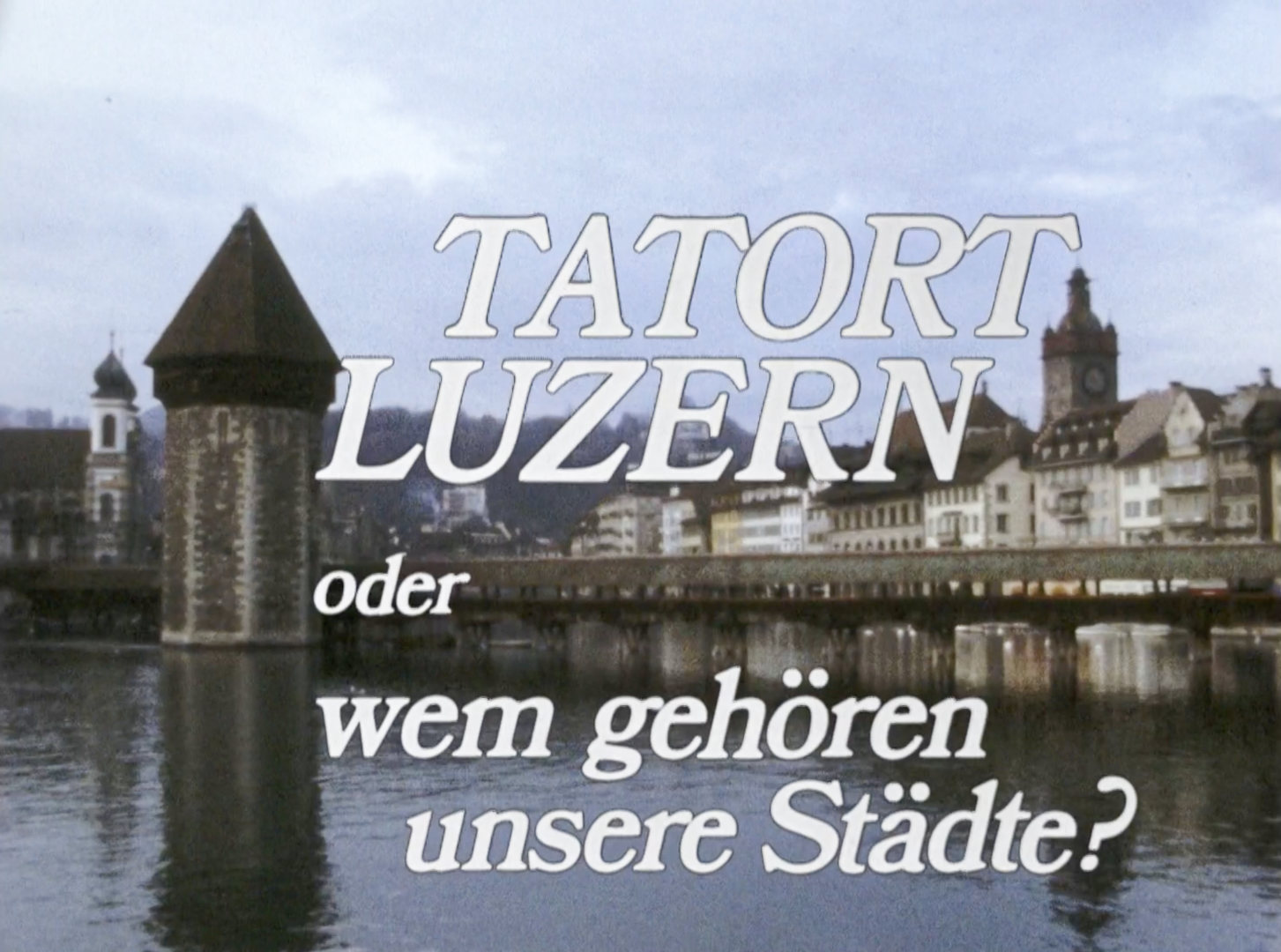 Filmtitel „Tatort Luzern – Wem gehören unsere Städte?“ über der Reuss mit der Kapellbrücke und dem Wasserturm in Luzern.